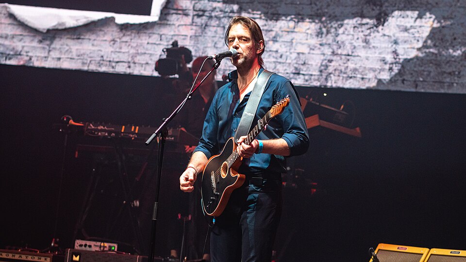 Ed O'Brien in a blue shirt singing at a microphone with a dark electric guitar, BBC 6 Music Festival at the Roundhouse, London, 7 March 2020